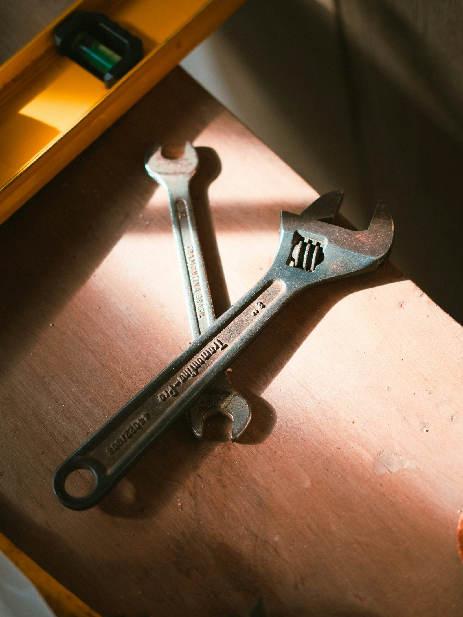 Wrenches and a spirit level on a wooden workbench